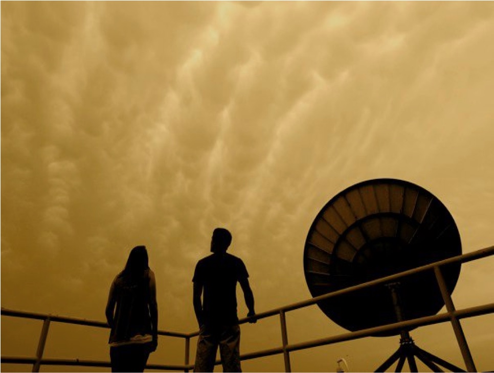 Two students watching a mammatus-filled sky from the CHAOS observation deck beside the satellite dish