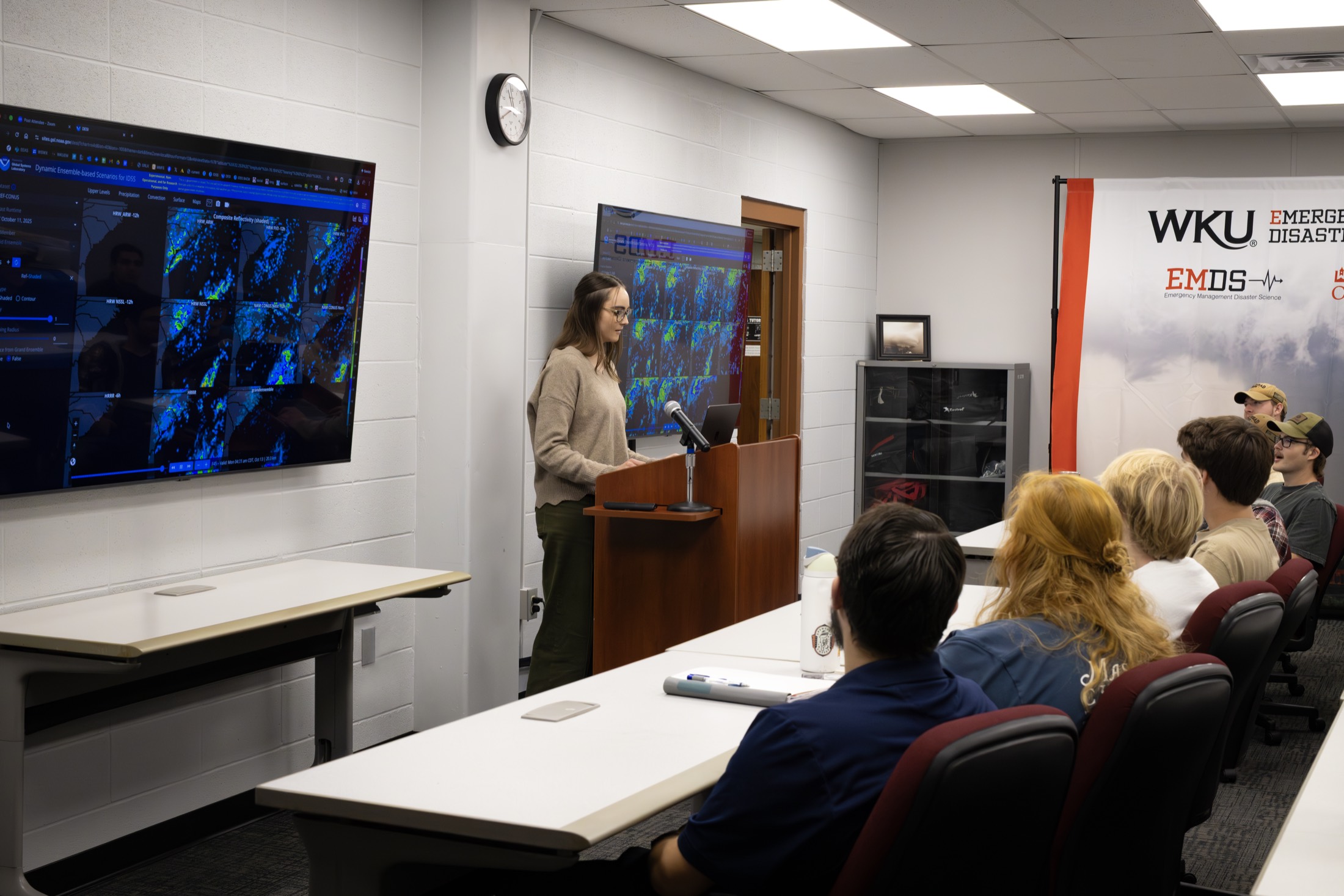 DSOC classroom with a projector wall of live weather data during a briefing