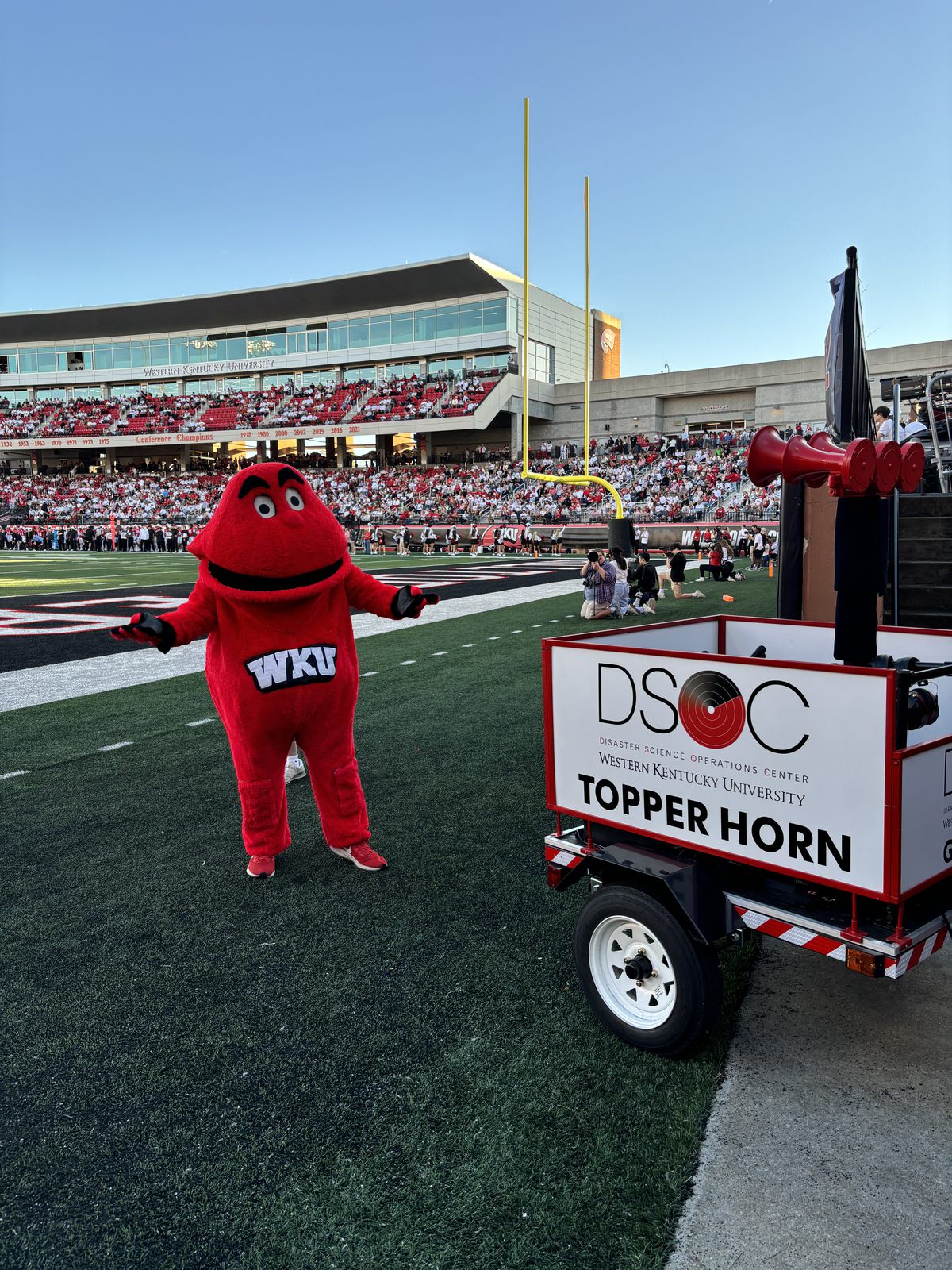 The DSOC Topper Horn trailer beside Big Red on the field at Houchens-Smith Stadium